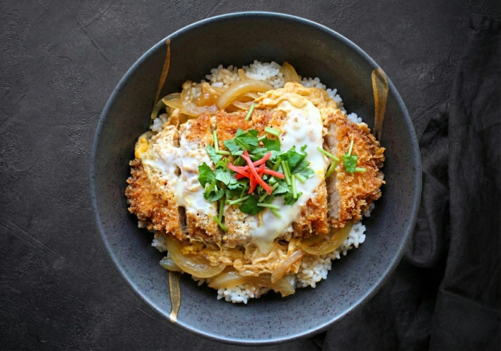 かつ丼 - サクサクの衣に包まれたジューシーな豚肉を特製の和風出汁で卵とじにした一品